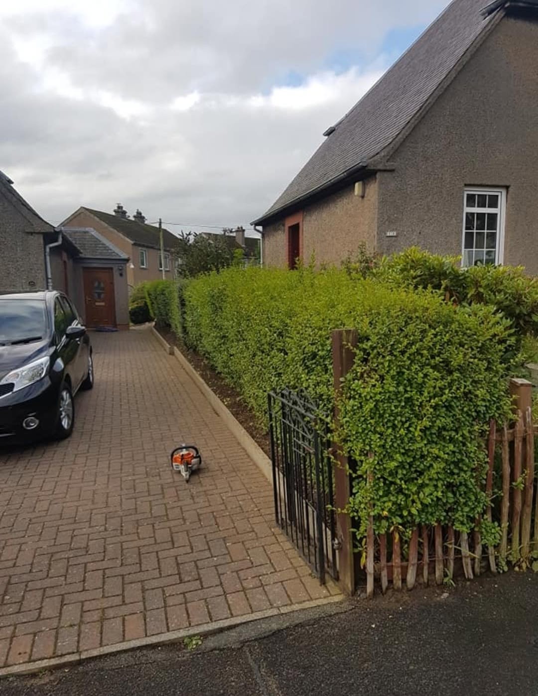 The same driveway hedge squared off and the paving swept, after